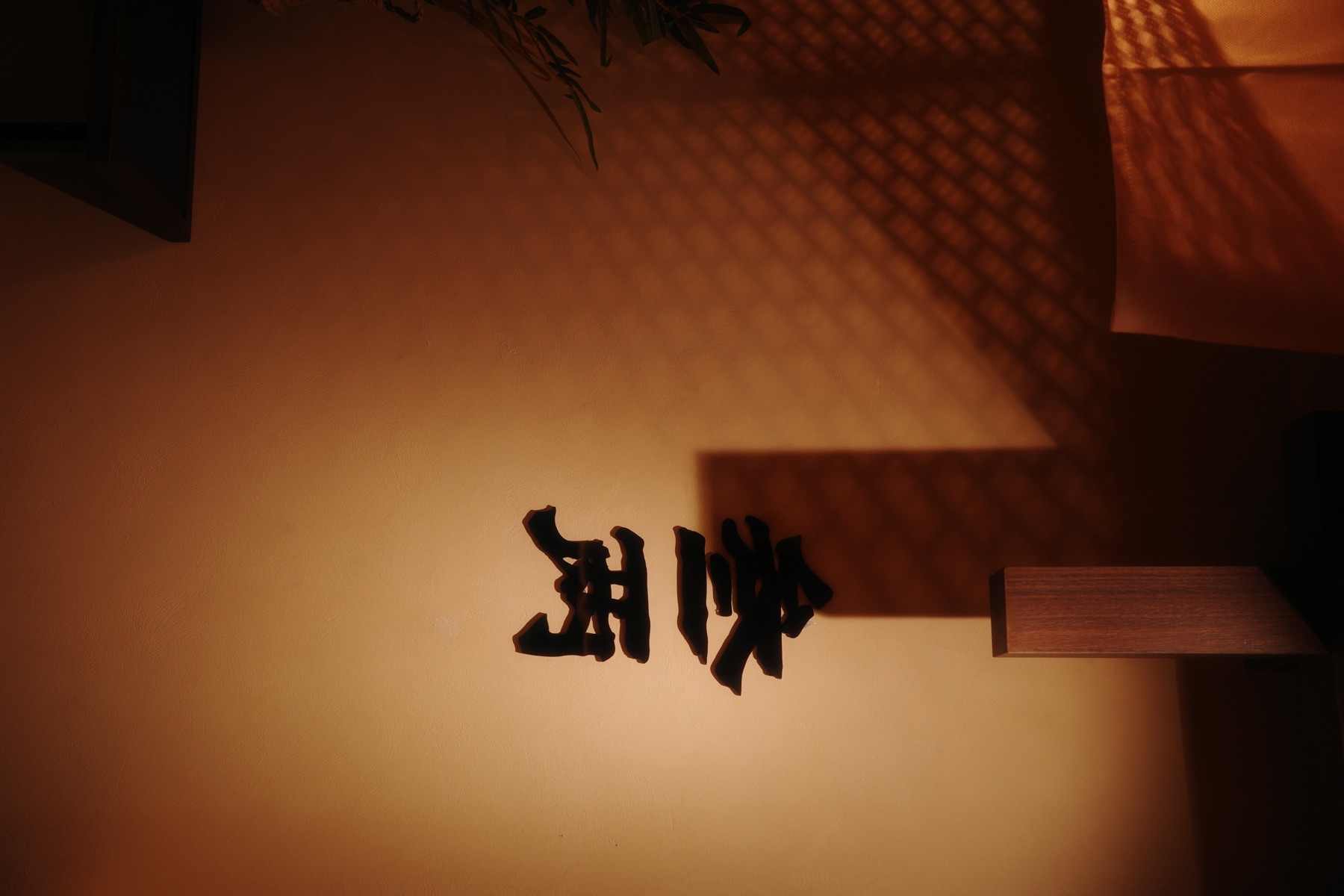 SUNLIT HOTPOT wall detail with warm light and restaurant signage