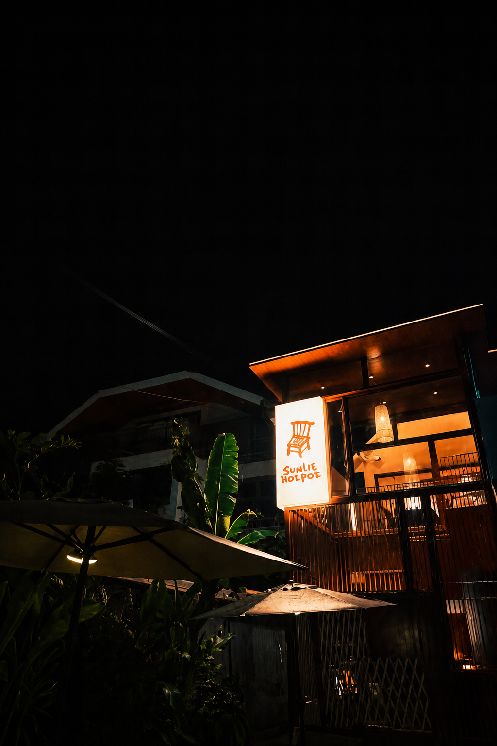 SUNLIT HOTPOT exterior glowing at night in Bangkok